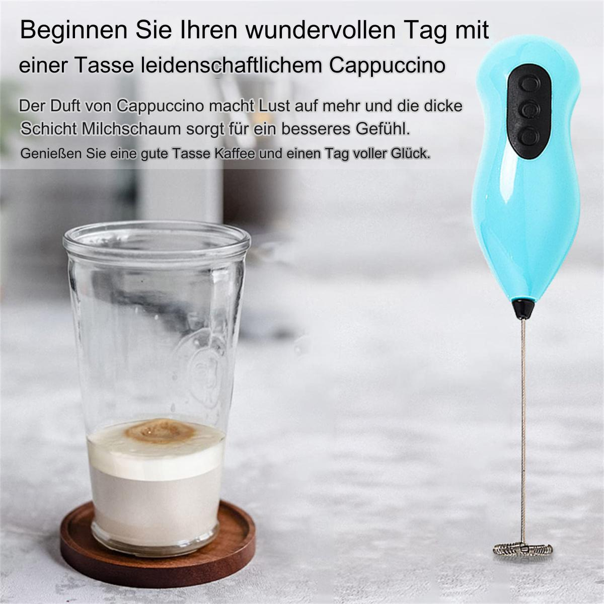 Ein blauer Milchaufschäumer, ein Glas Cappuccino und ein Holzuntersetzer.