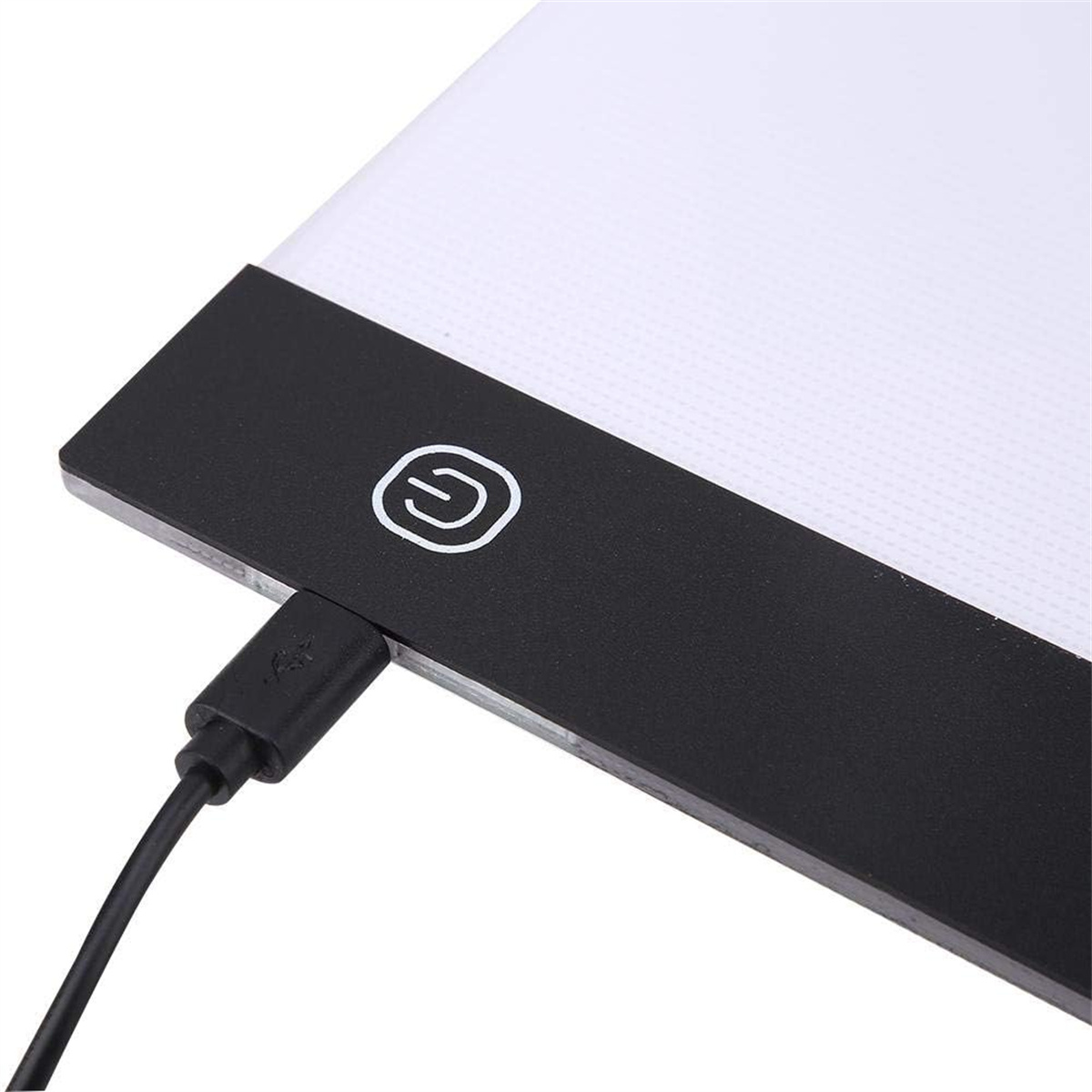 Leuchtpad mit schwarzem Rahmen und einem Einschaltknopf. Ein USB-Kabel ist eingesteckt. Die Oberfläche ist beleuchtet.