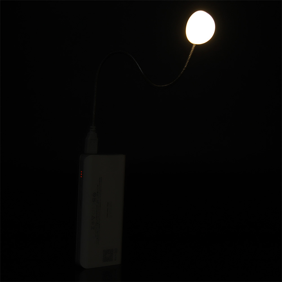 Ein schwarzer Hintergrund mit einer flexiblen Leuchte und einer Powerbank. Ein kleines Licht ist an der Powerbank befestigt.