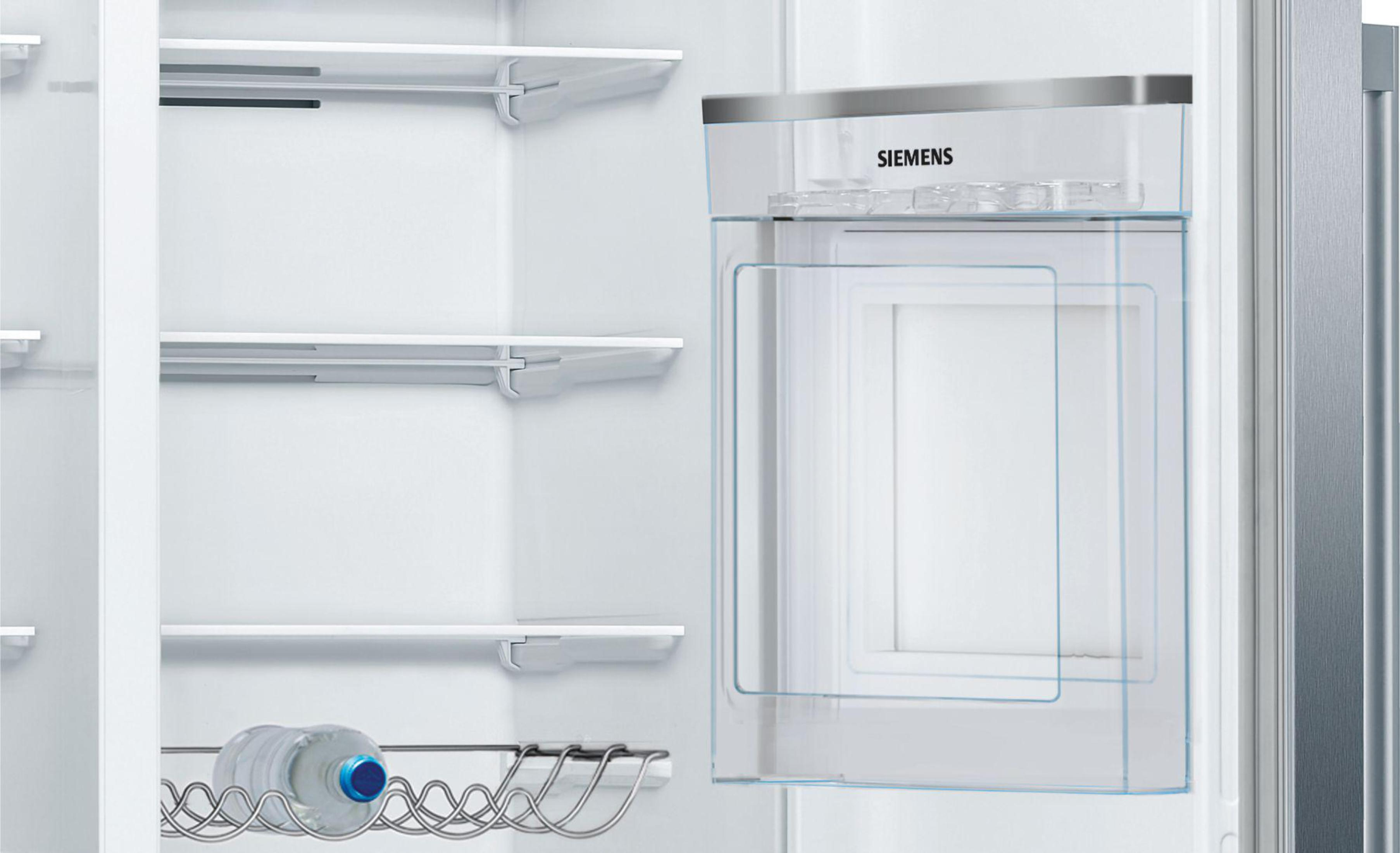 Pusta lodówka z półkami i butelką wody. Logo Siemens u góry.