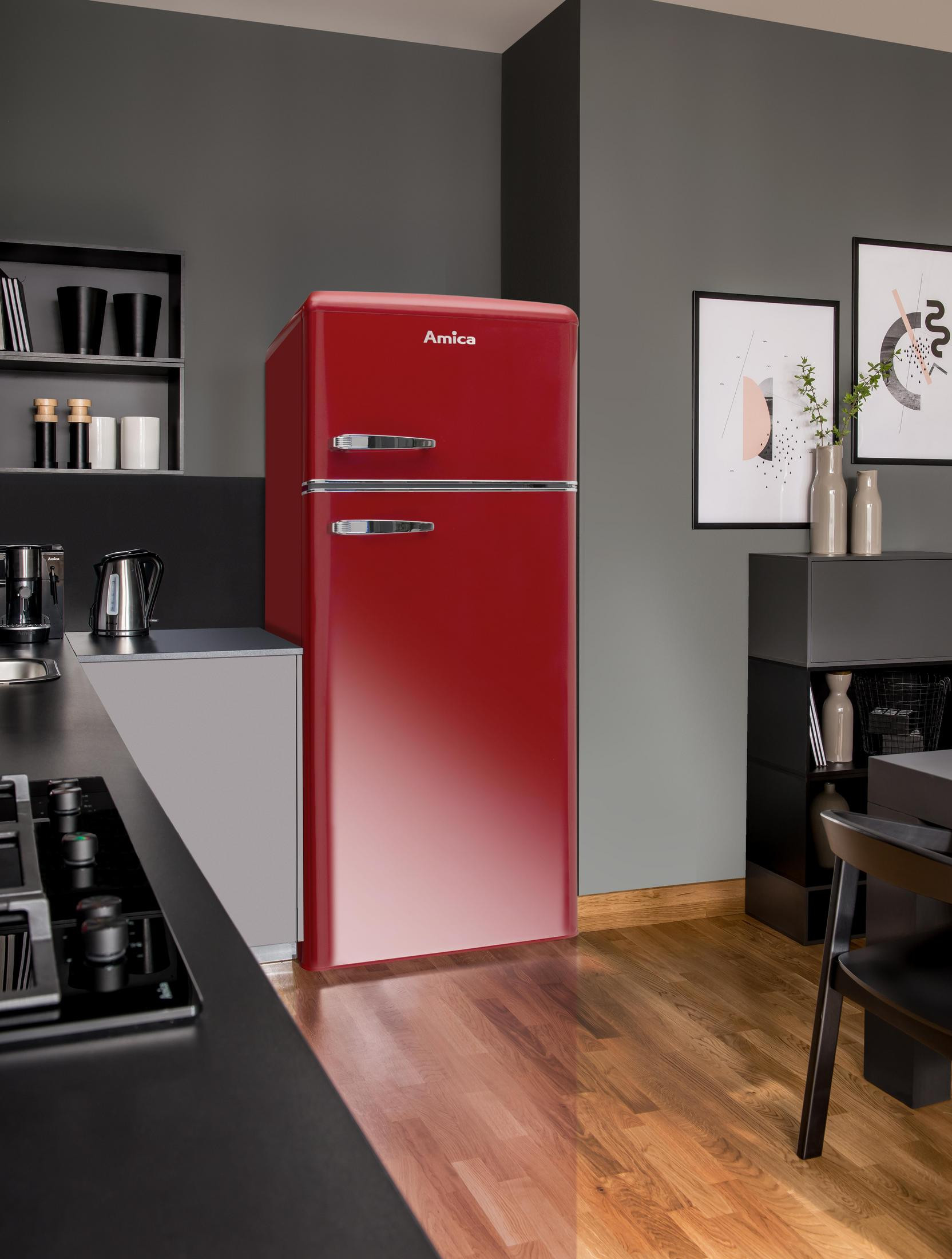 Ein roter Kühlschrank im Retro-Stil in einer Küche mit schwarzer Arbeitsplatte, Schränken und Holzboden.