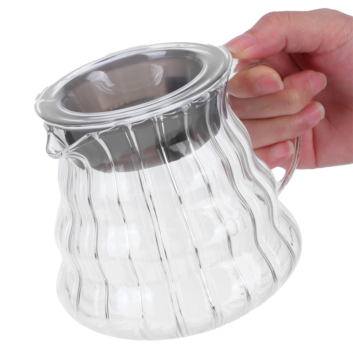 Ein klares Glaskrug mit Edelstahlrand, gehalten von einer Hand. Der Krug ist leer.