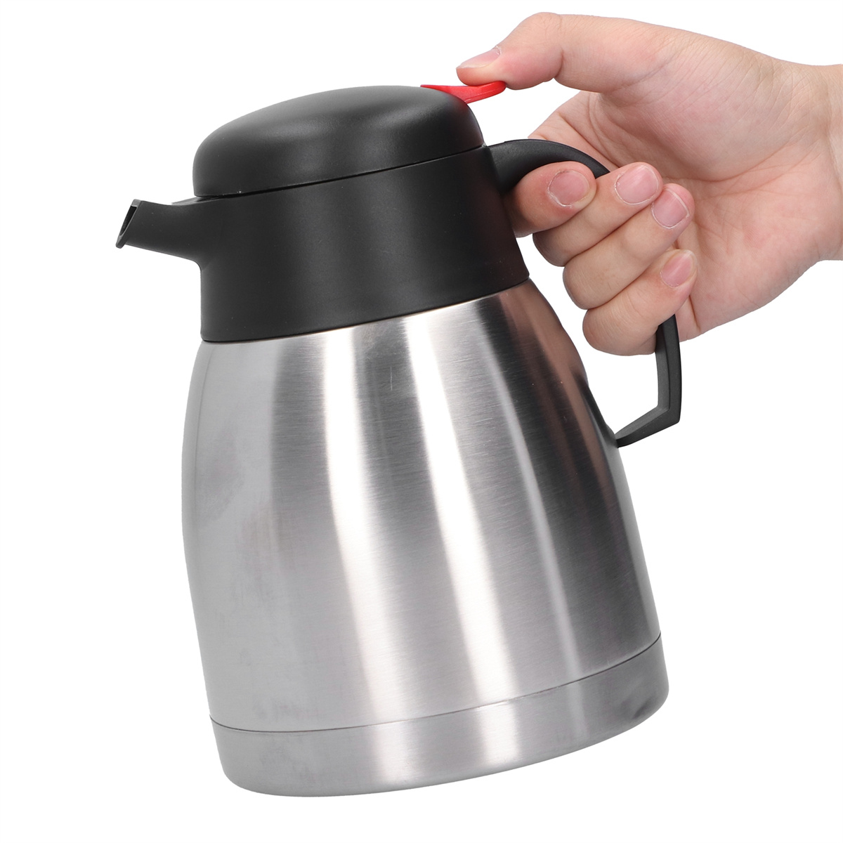 Eine Person hält eine silberne und schwarze isolierte Kaffeekanne.