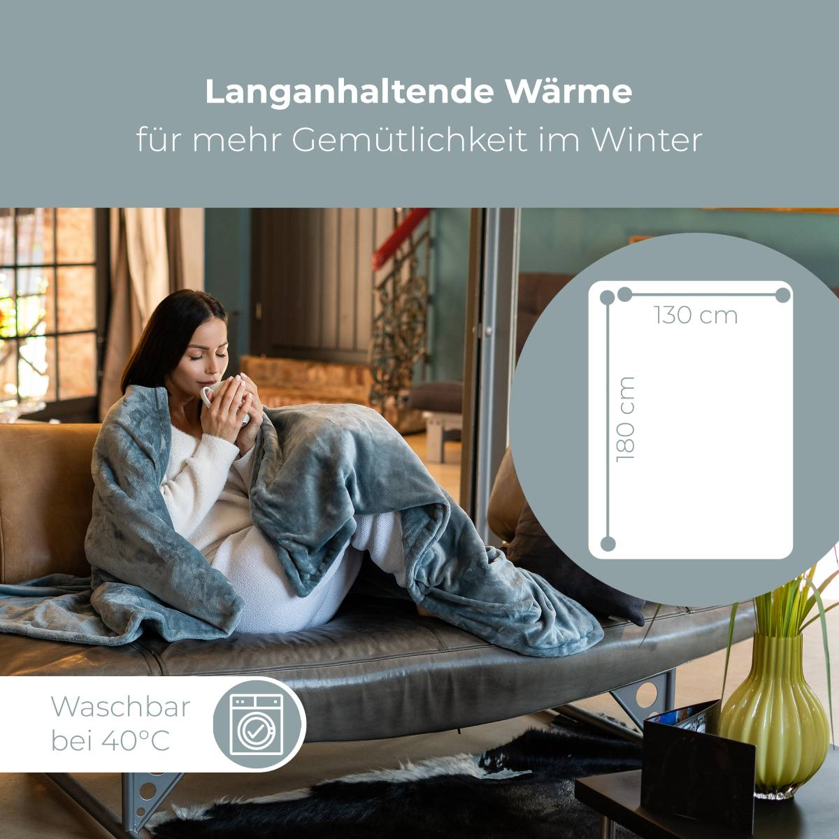 Kobieta owinięta szarym kocem trzyma kubek na skórzanej kanapie. Tekst wskazuje wymiary.