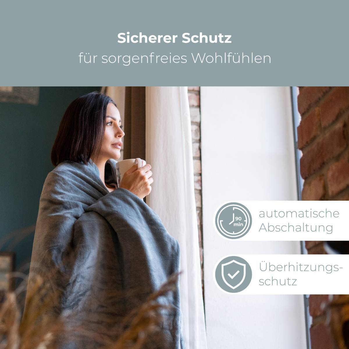 Kobieta owinięta w szary koc patrzy przez okno. Tekst: Sicherer Schutz für sorgenfreies Wohlfühlen.
