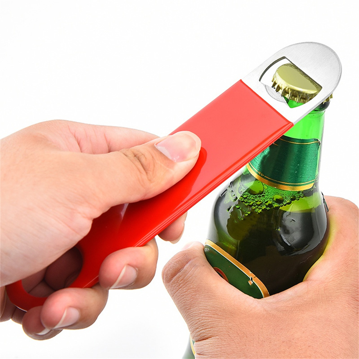 Ein roter Flaschenöffner öffnet eine grüne Bierflasche. Zwei Hände halten die Flasche.