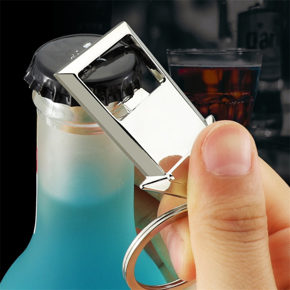 Hand öffnet eine Flasche mit einem silbernen Flaschenöffner. Blaue Flüssigkeit und Kronkorken sind sichtbar.