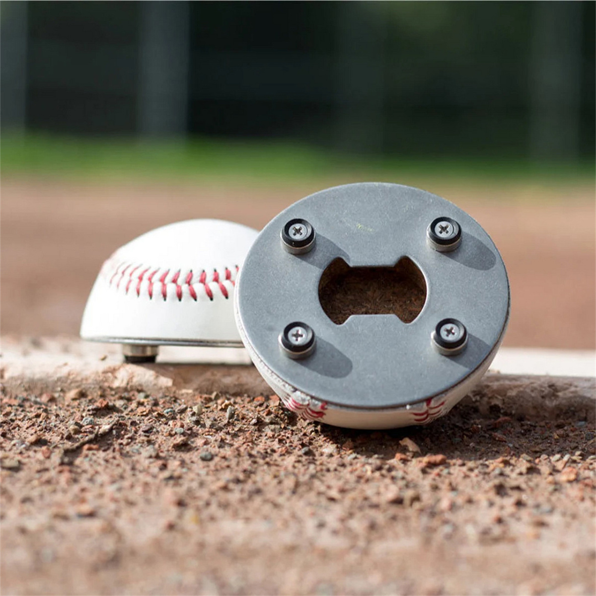 Ein baseballförmiger Flaschenöffner. Der Baseball ist weiß mit roten Nähten, auf einer braunen Oberfläche.