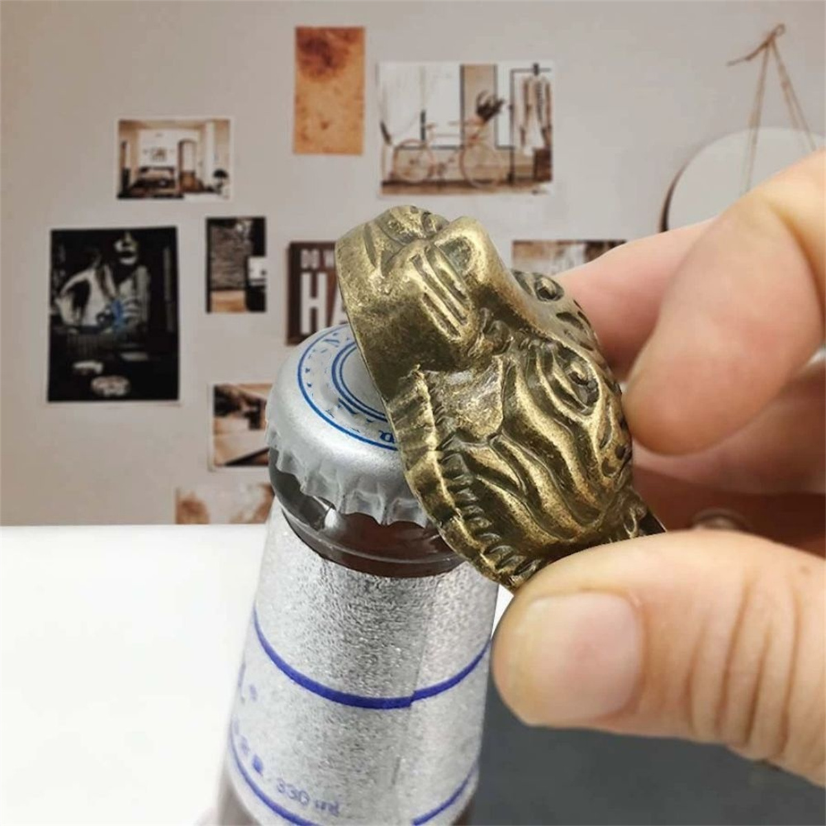 Eine Flasche wird mit einem bronzenen Flaschenöffner in Form eines Löwenkopfes geöffnet. Der Hintergrund hat Bilder.