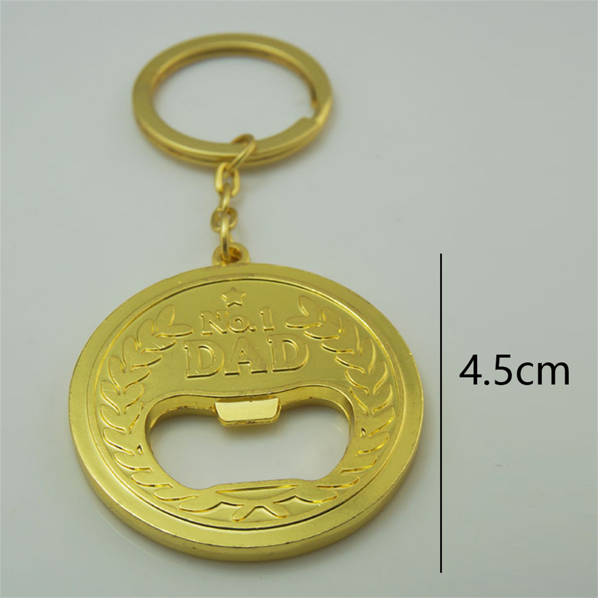 Ein goldener Flaschenöffner-Schlüsselanhänger mit der Aufschrift „No. 1 DAD“ und einer Höhe von 4,5 cm.