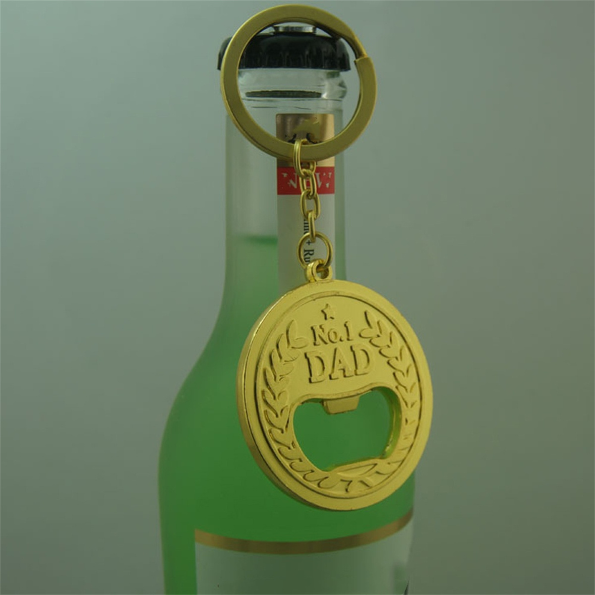 Goldener Flaschenöffner-Schlüsselanhänger mit 'No.1 Dad'-Münze.