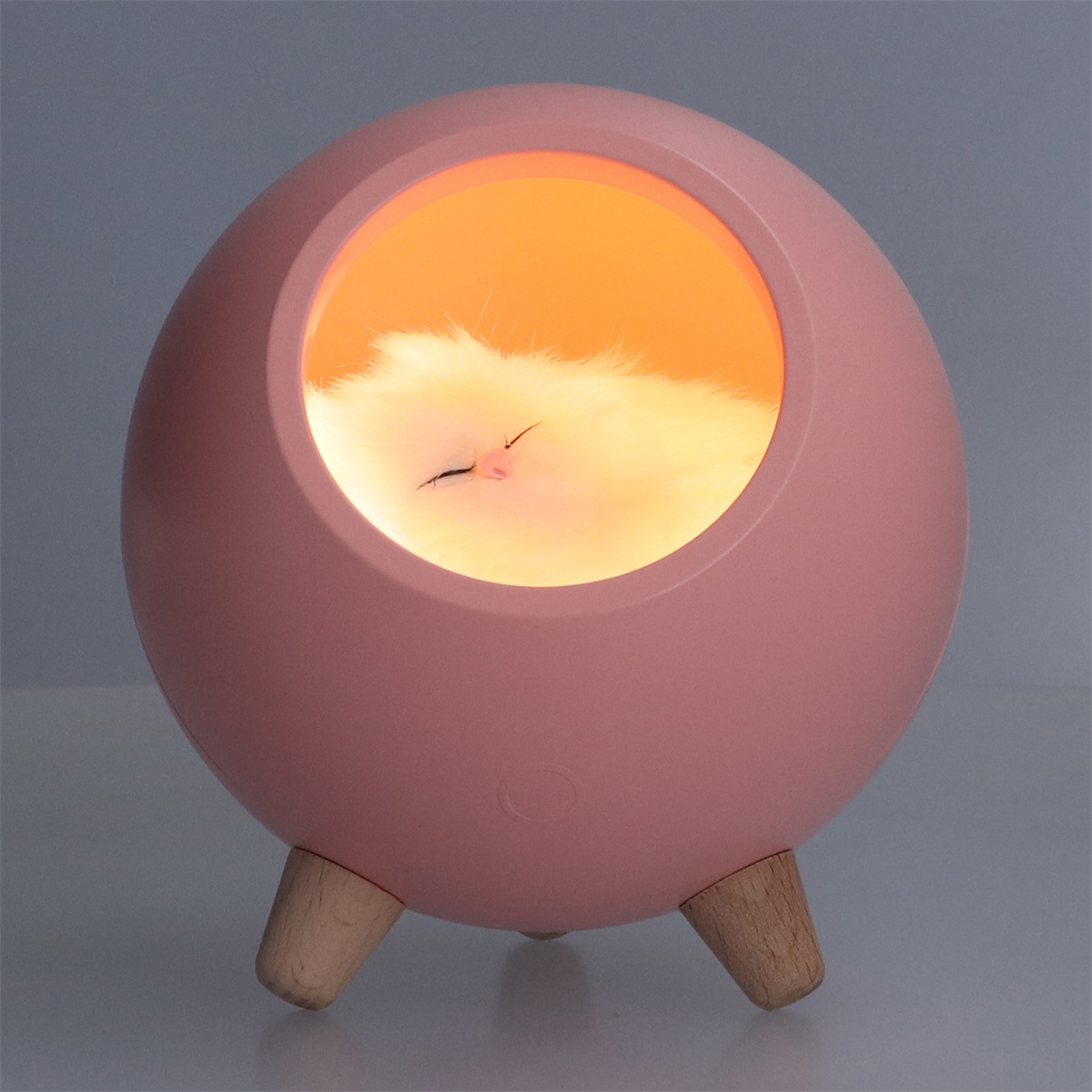 Ein rosa eiförmiges Nachtlicht mit einem schlafenden Katzenbild im Inneren.