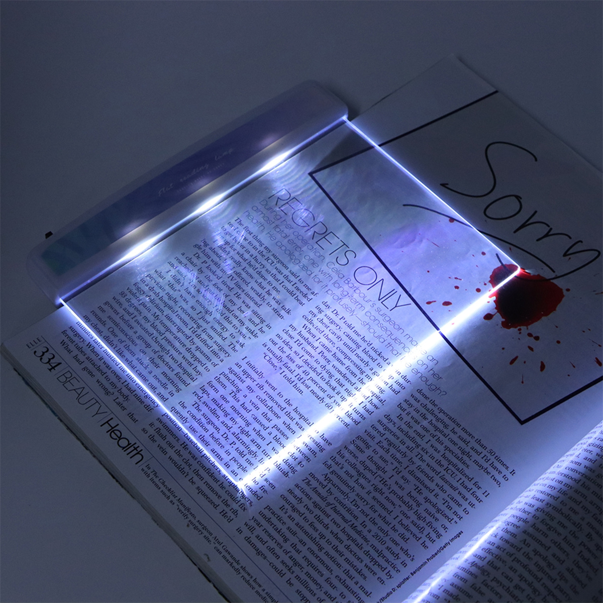 Ein Licht scheint auf eine offene Zeitschrift. Das Wort Sorry ist auf der Seite zu sehen.