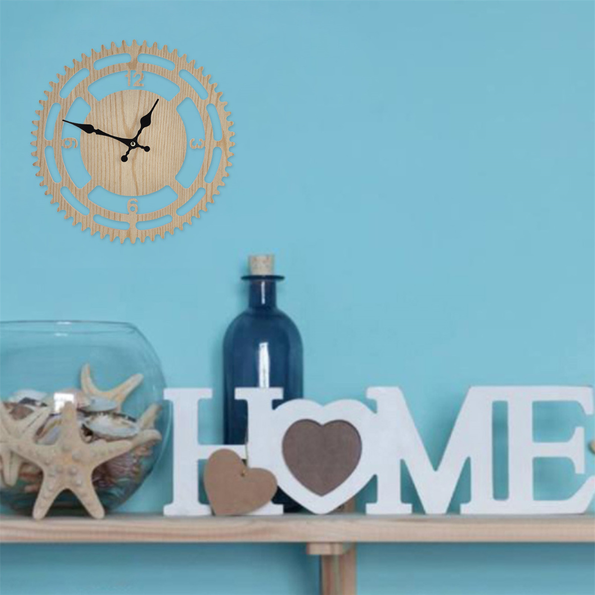 Eine Holzuhr an einer blauen Wand, mit dekorativen Gegenständen: ein HOME-Schild und Seesterne.