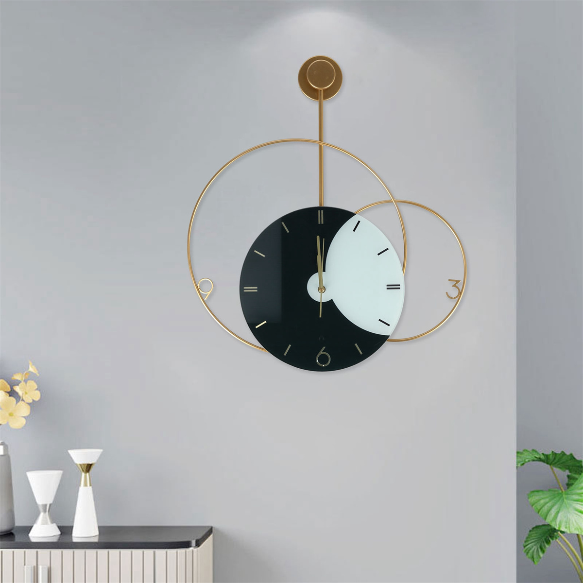 Goldene und schwarze Wanduhr mit kreisförmigem Design, Zeiger zeigen die Zeit.