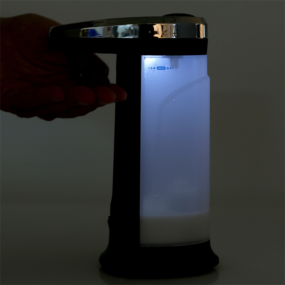 Automatischer Seifenspender, weiße Flüssigkeit sichtbar. Licht scheint durch den Behälter.