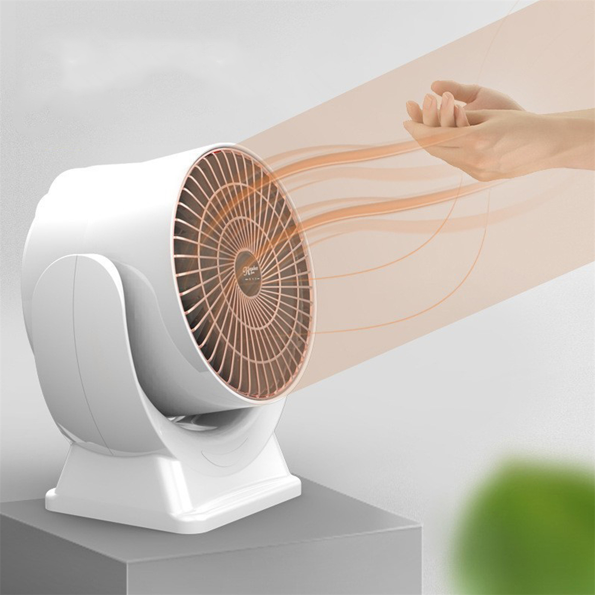 Weißer Heizlüfter, der orangefarbene Luft in Richtung einer Hand auf grauem Hintergrund bläst.