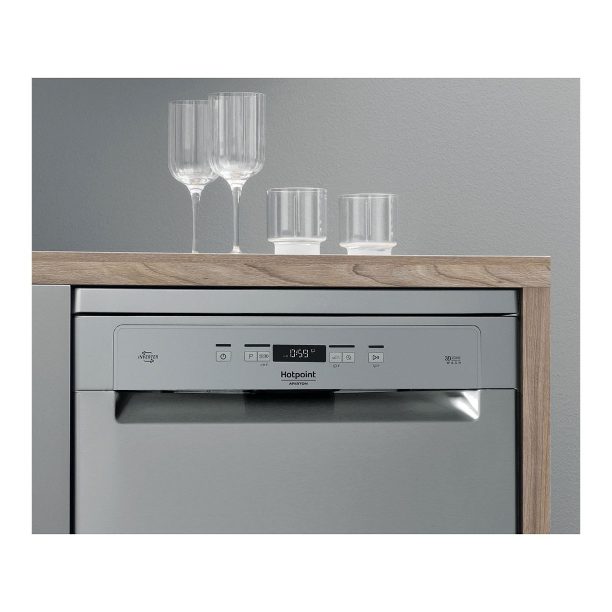 Lavavajillas con copas encima, encimera de madera, fondo gris.