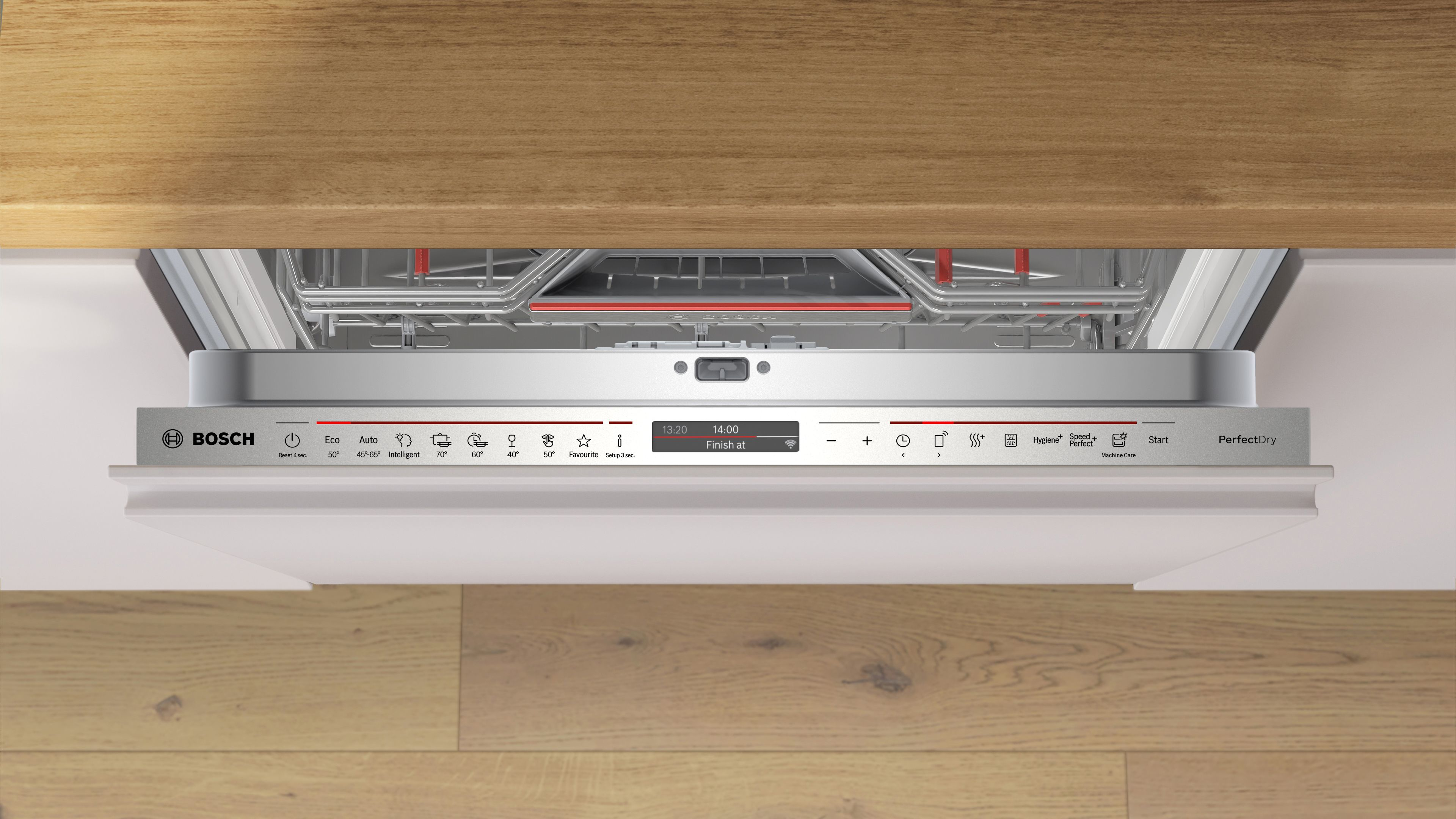 Wnętrze zmywarki, otwarte, z panelem sterowania u góry. Widoczna drewniana szafka i podłoga.