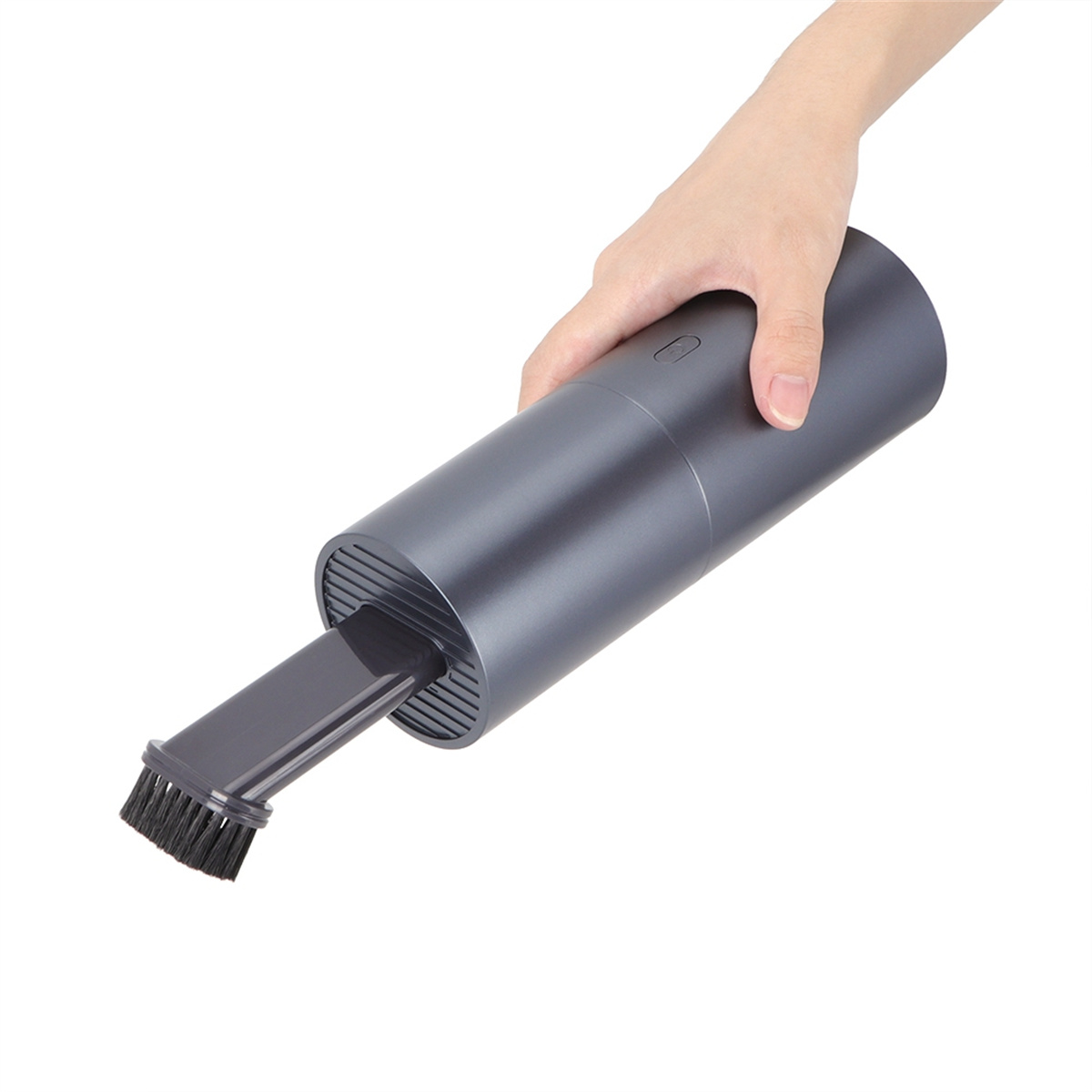 Hand hält einen grauen Handstaubsauger mit einem Bürstenaufsatz.