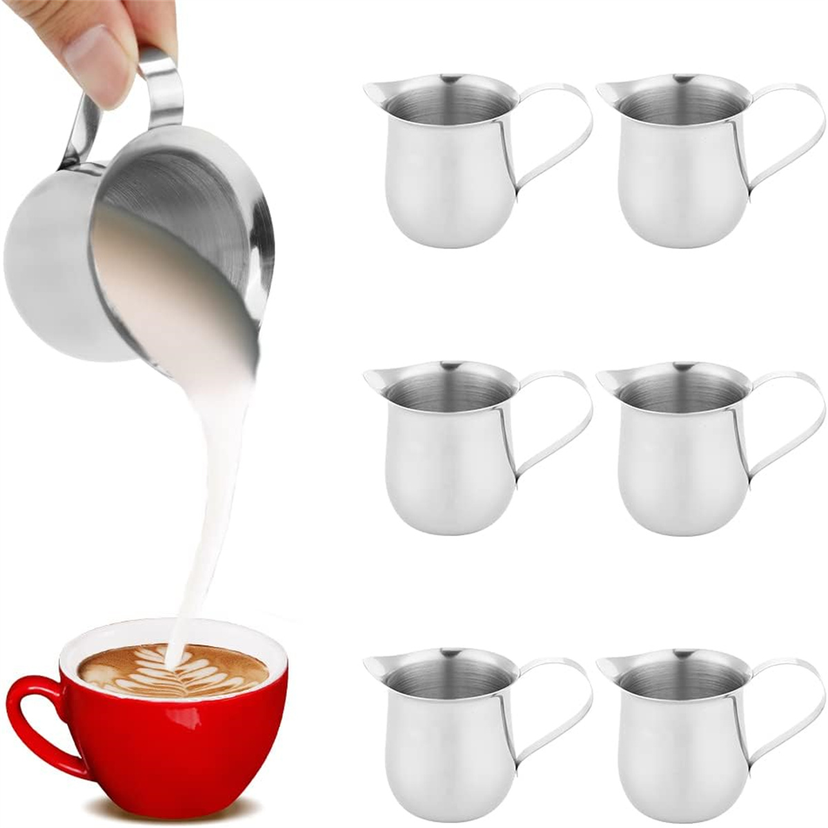 Milch gießt aus einem Metallkrug in eine rote Tasse mit Kaffee-Kunst, umgeben von weiteren Krügen.