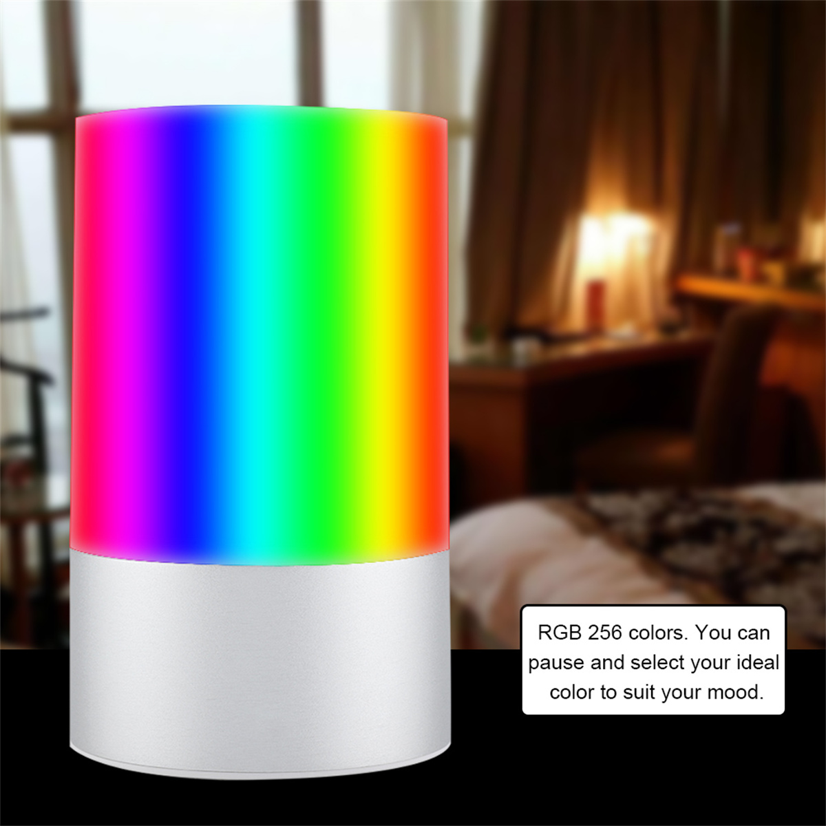 Eine zylindrische Lampe, die einen Regenbogen von Farben ausstrahlt. Die Lampe steht auf einer dunklen Oberfläche und hat einen silbernen Sockel.