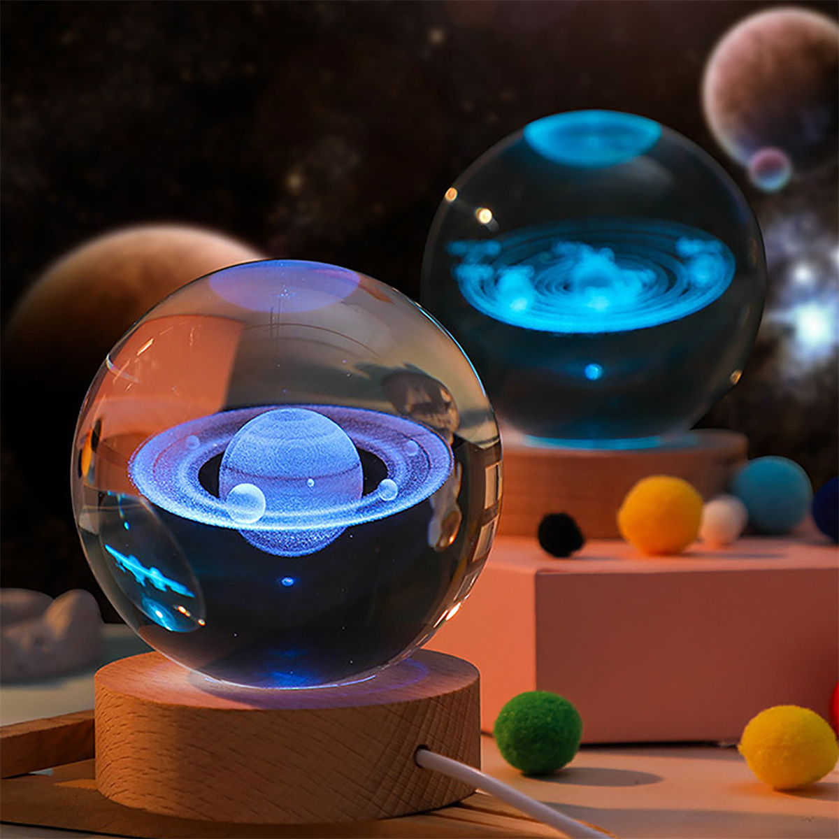Zwei Glaskugeln mit Planeten im Inneren, blau beleuchtet, auf einem Holzsockel mit bunten Kugeln.