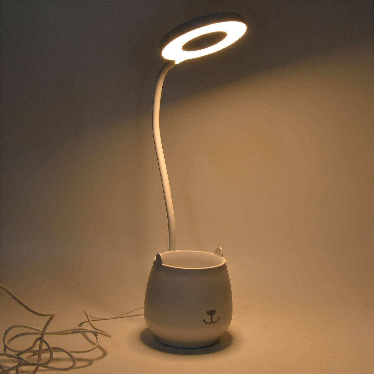 Weiße Schreibtischlampe in Bärenform mit hellem Ringlicht.