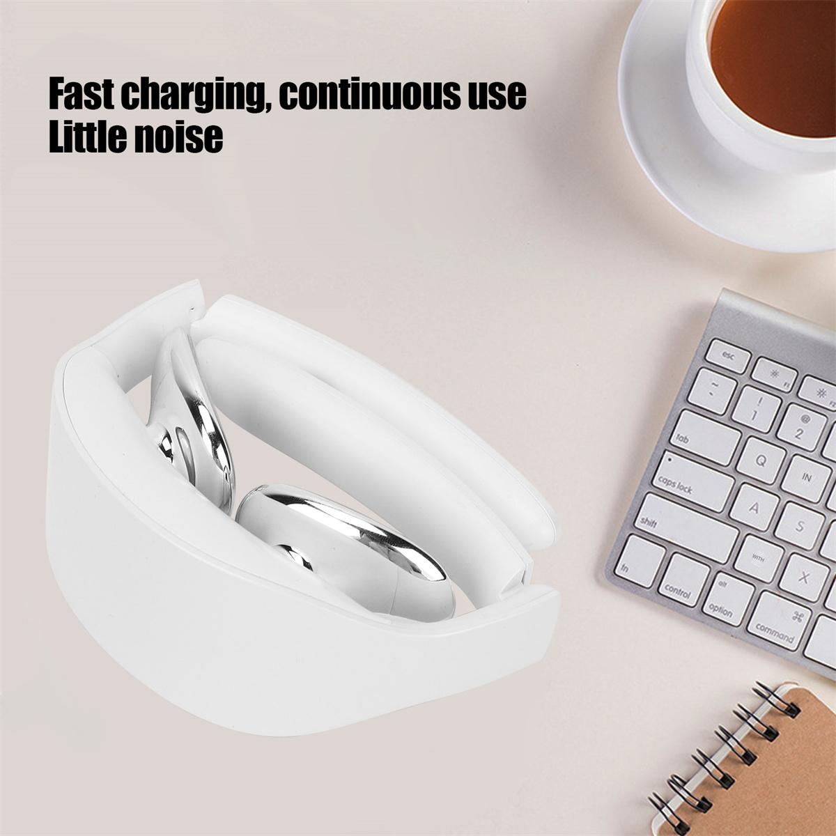 Weißes Nackenmassagegerät auf dem Schreibtisch, neben Tastatur und Tasse.