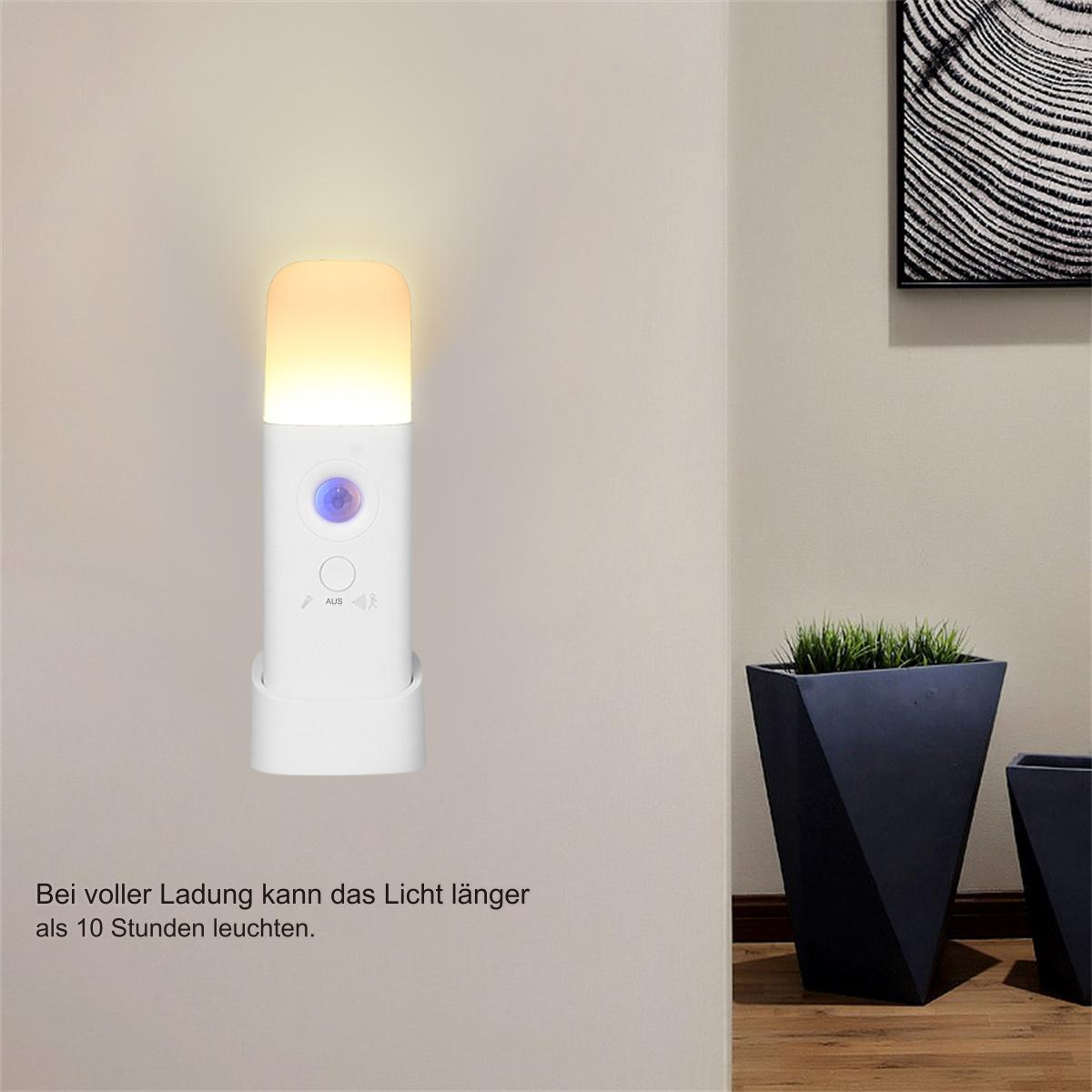 Wandmontiertes Nachtlicht mit Licht, Sensor und Sockel. Ein schwarzer Pflanzentopf ist im Hintergrund.