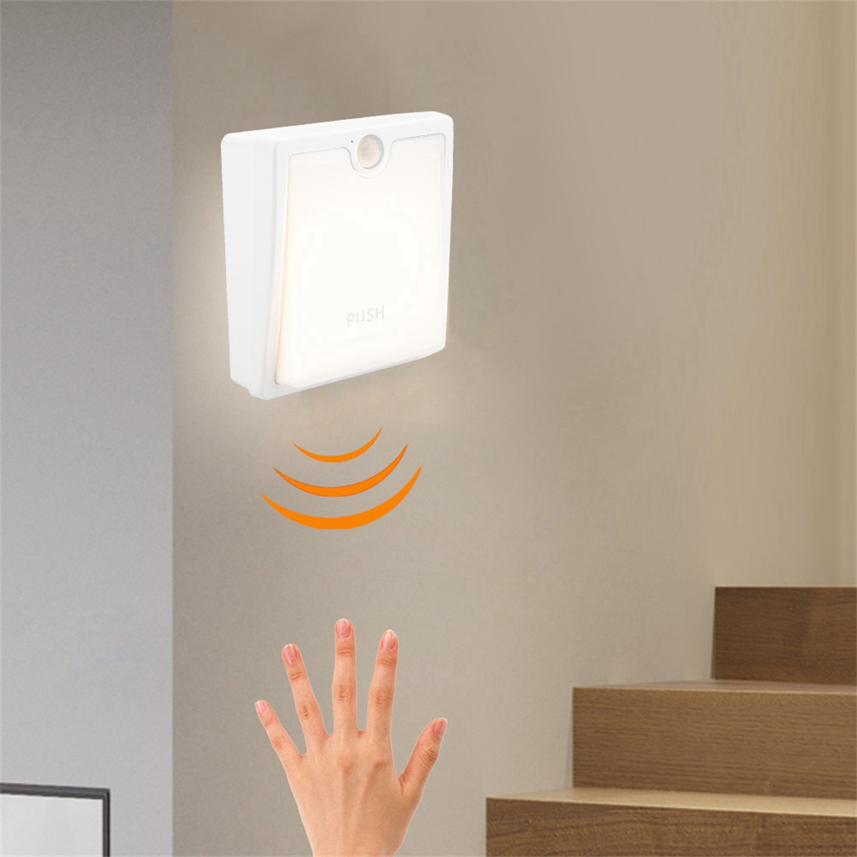 Weiße Wandleuchte mit Sensor. Eine Hand greift nach dem Licht. Treppe im Hintergrund.