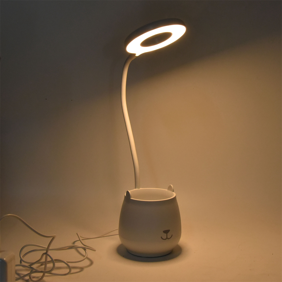 Weiße Schreibtischlampe mit Ringlicht und kleinem Becherfuß.
