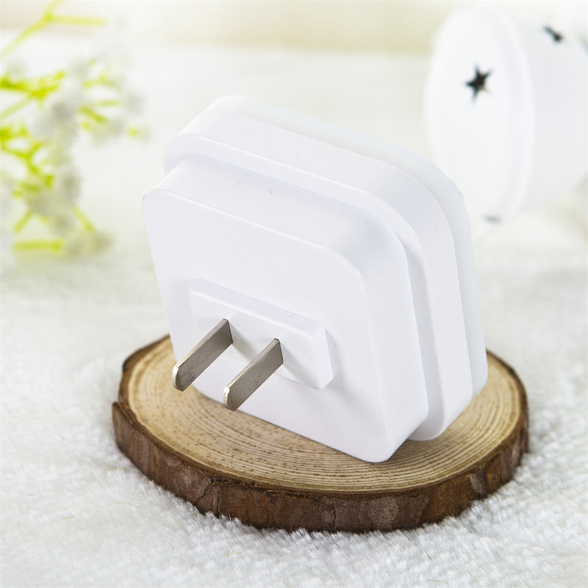 Weißer Steckdosenadapter auf einer Holzoberfläche.