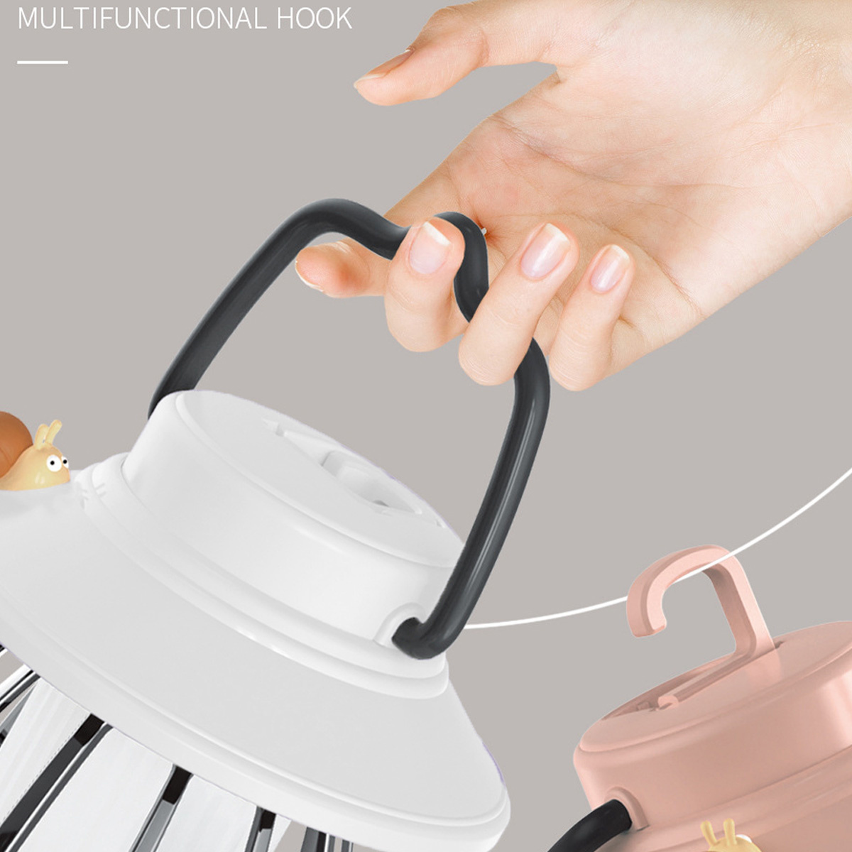Hand hält eine weiße und rosa Lampe mit schwarzem Griff. Die Lampe hat eine Hakenform.