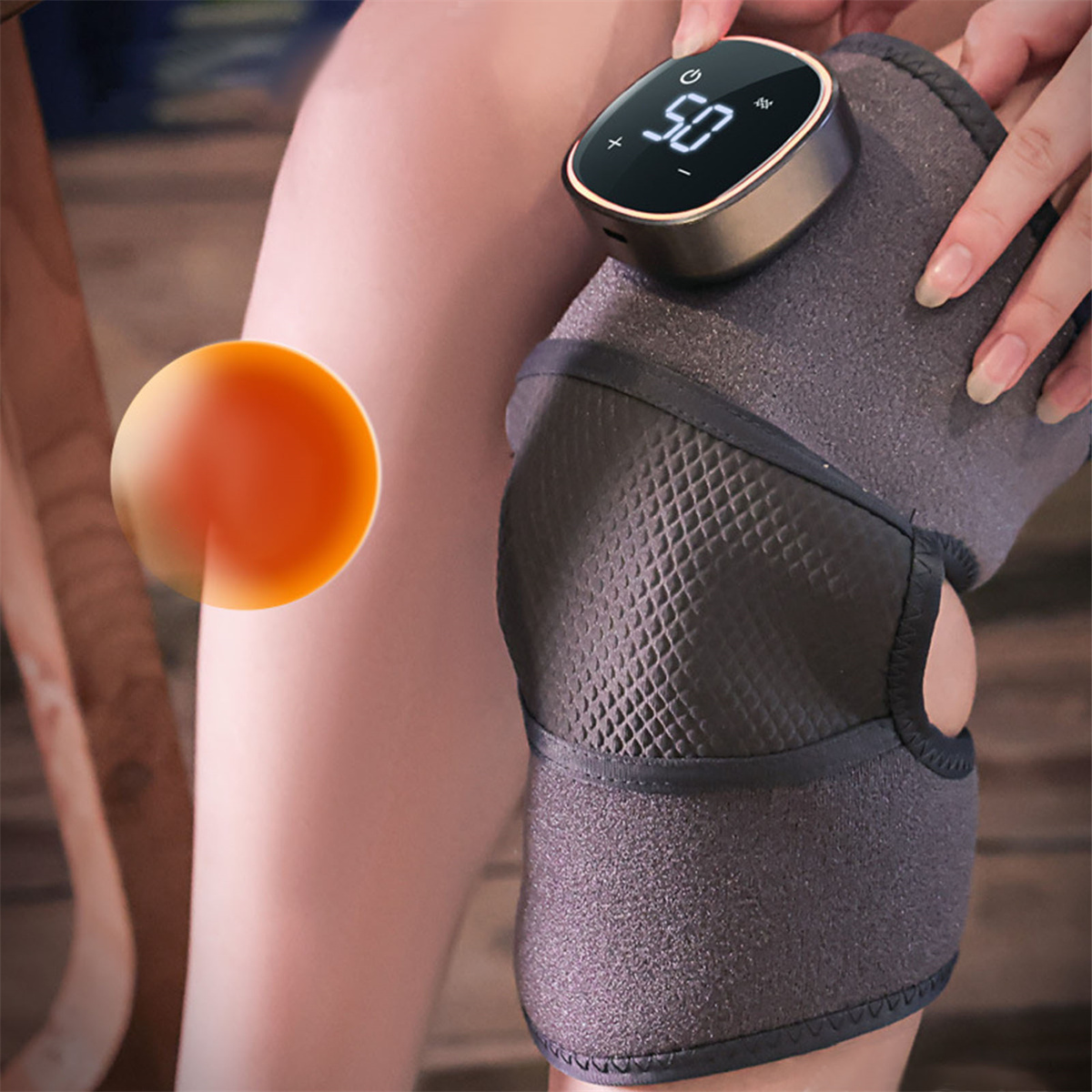Das Knie einer Person mit einem Wärmetherapiegerät. Das Gerät zeigt eine Temperatur von 50 Grad an.