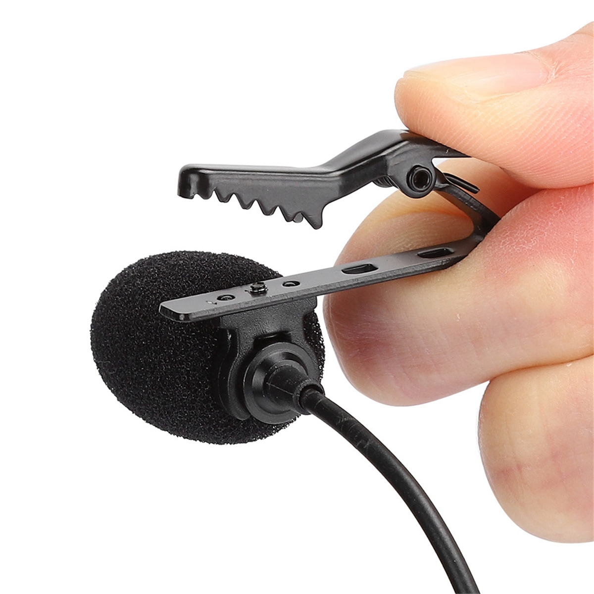 Ein kleines, schwarzes Lavalier-Mikrofon mit Schaumstoffhülle, befestigt an einer Klammer, gehalten von Fingern.