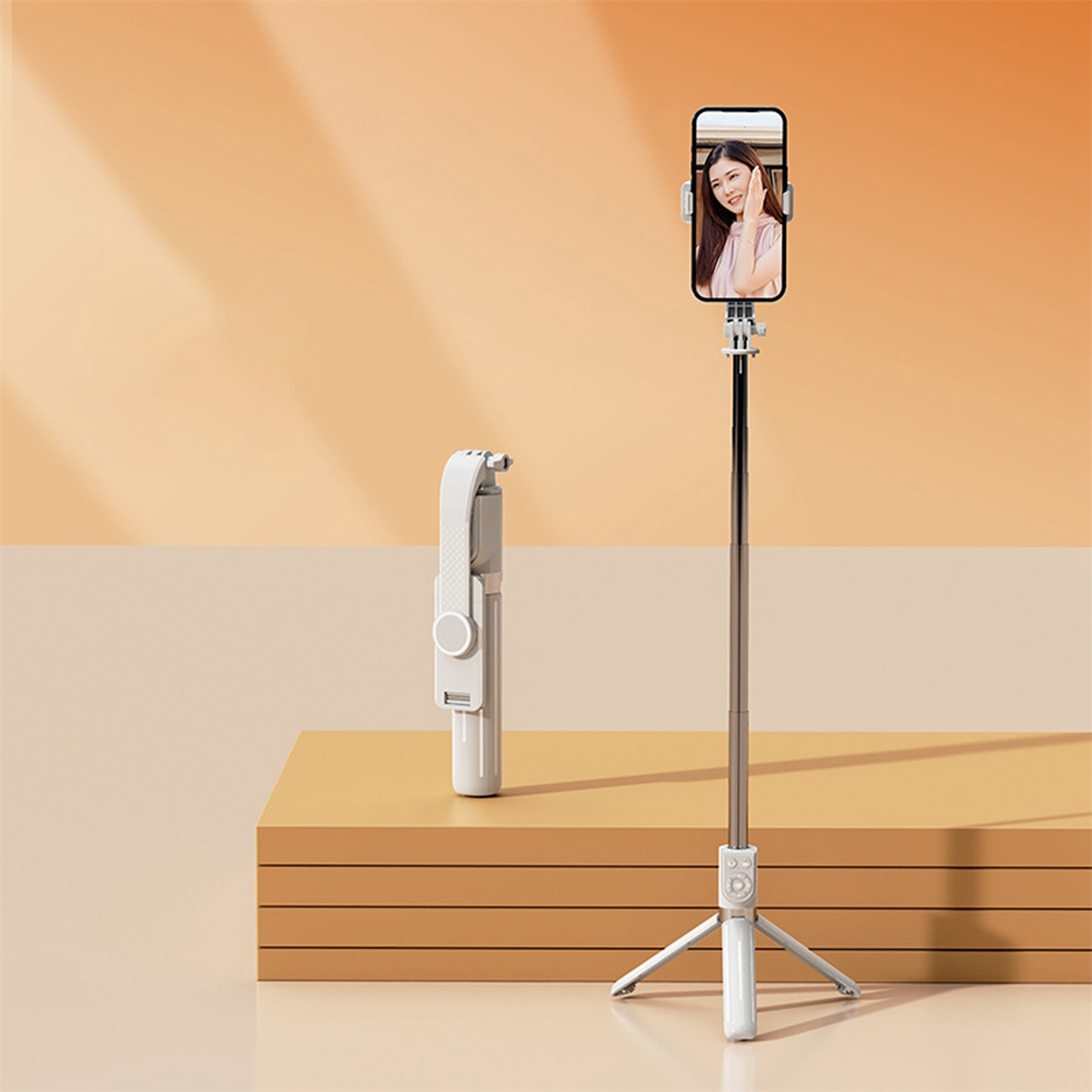 Ein Selfie-Stick mit einem daran montierten Telefon. Eine Person ist auf dem Telefonbildschirm sichtbar, daneben ein zweiter Stick.