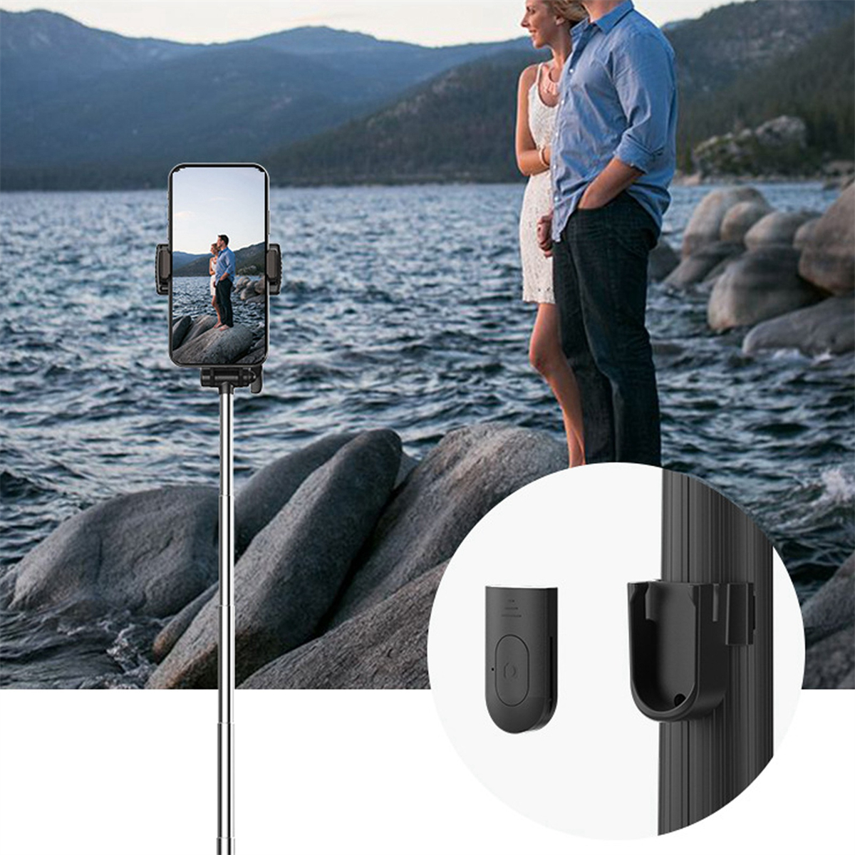 Ein Telefon an einem Selfie-Stick. Ein Paar ist im Hintergrund am Wasser sichtbar.