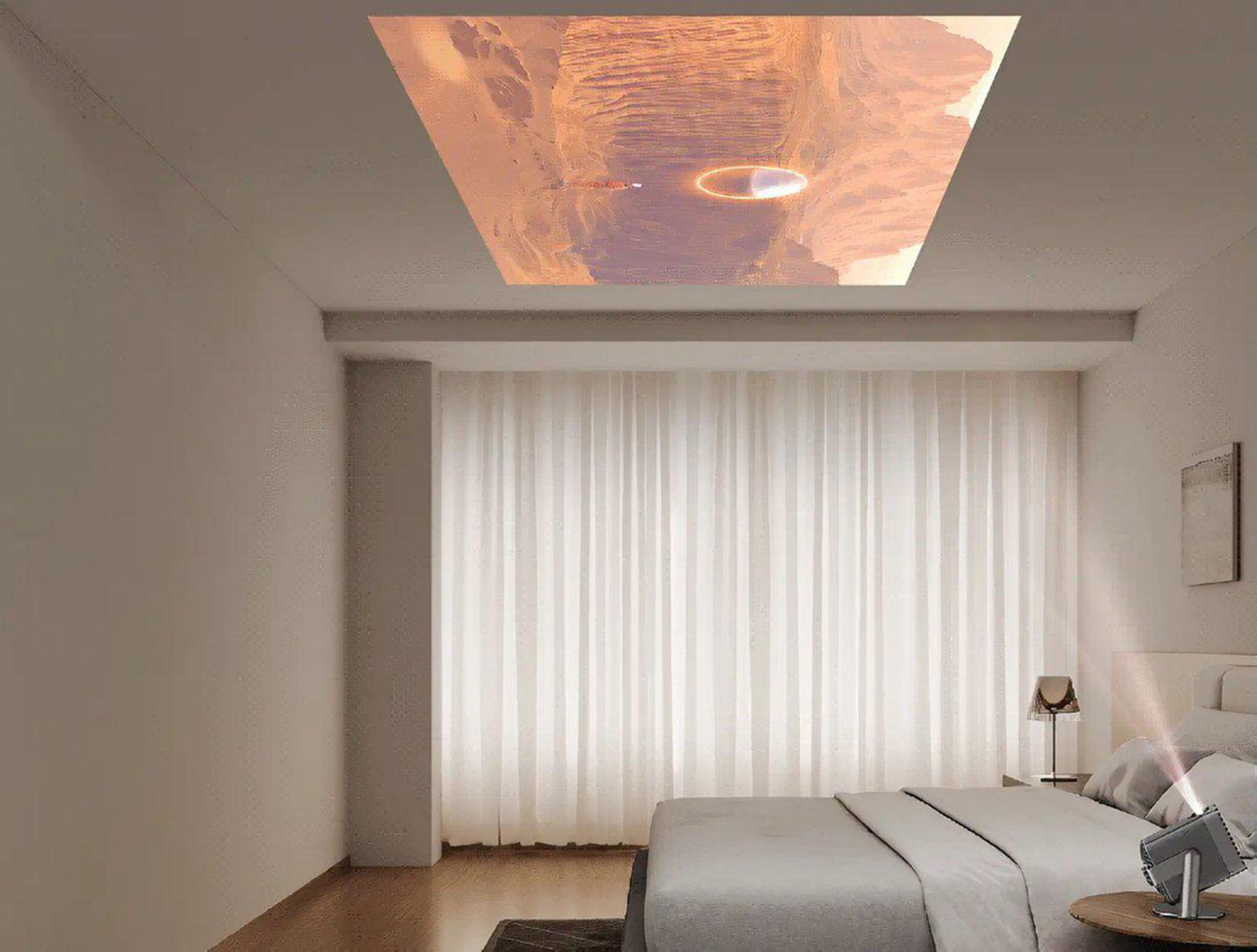 Una habitación con una imagen proyectada en el techo. Se ve una cama y una mesita de noche.