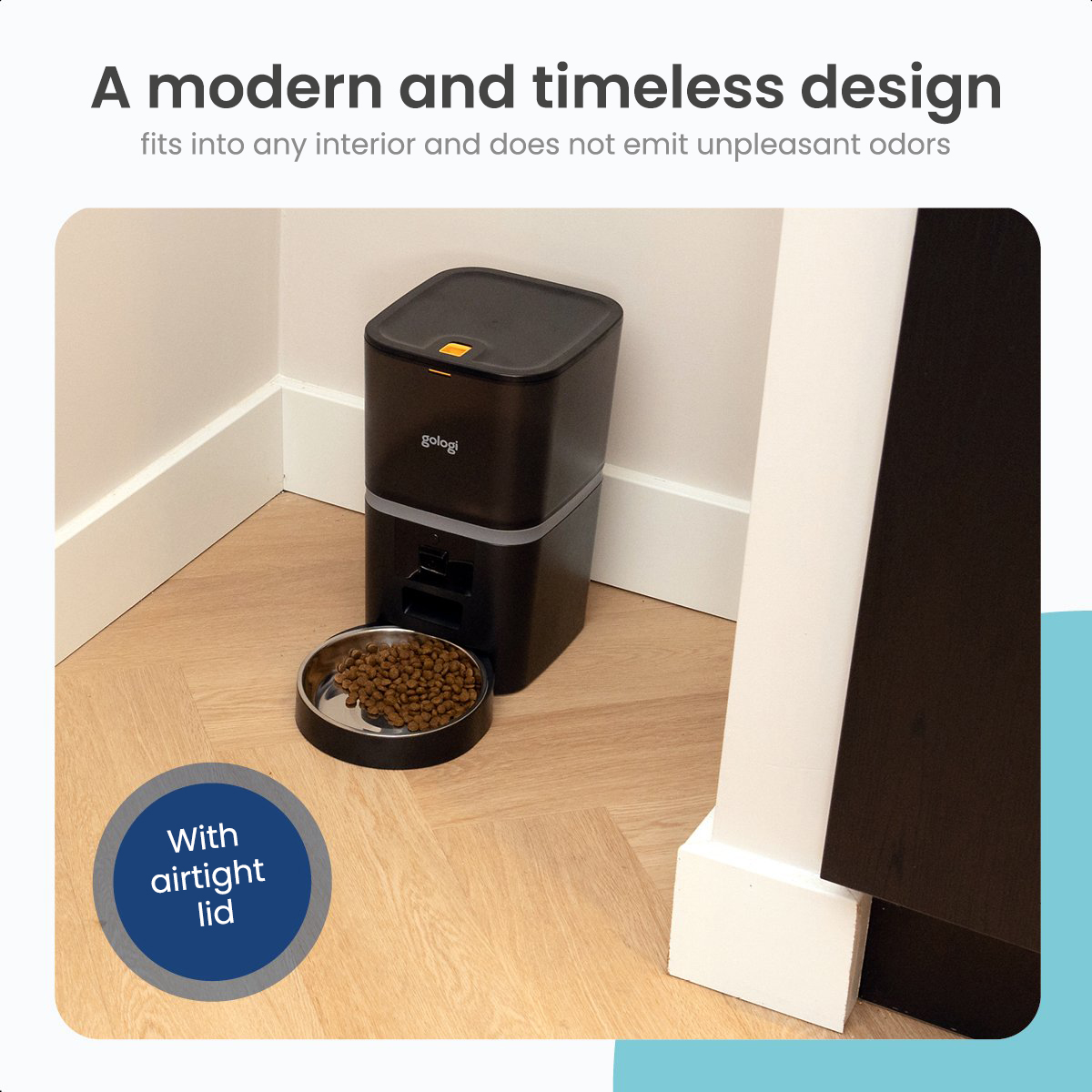 Black pet food dispenser with a silver bowl, filled with food on a wooden floor.