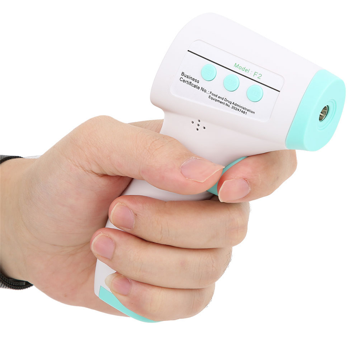 Die Hand einer Person hält ein weißes und türkisfarbenes Infrarot-Thermometer. Das Gerät hat Knöpfe und ein Display.