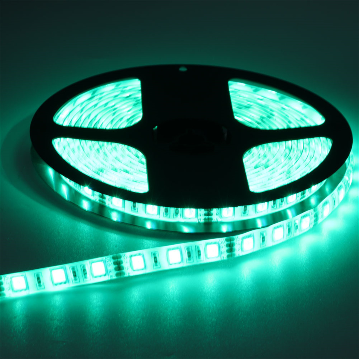 Eine Rolle grüner LED-Streifen auf dunklem grünen Hintergrund.