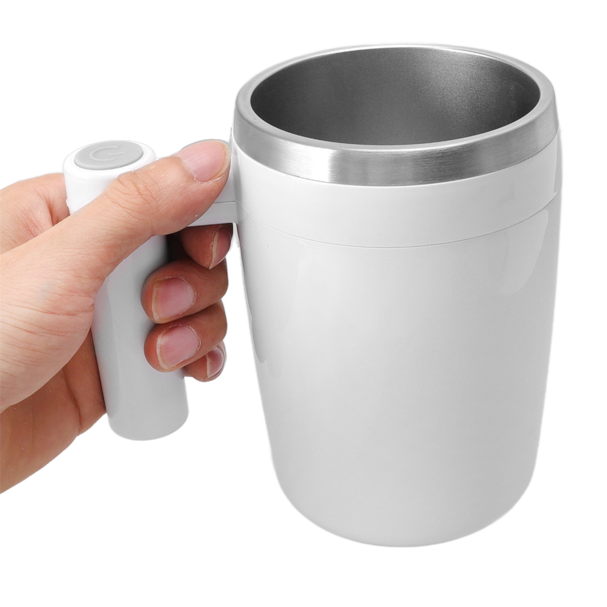 Eine Hand hält eine selbstverrührende weiße Tasse mit silbernem Rand und Griff mit Knopf.