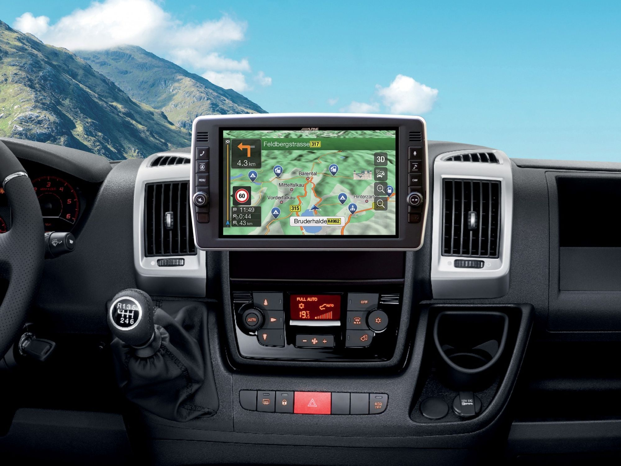 Armaturenbrett eines Autos mit Navigationsbildschirm, der eine Karte und einen Berg im Hintergrund anzeigt.