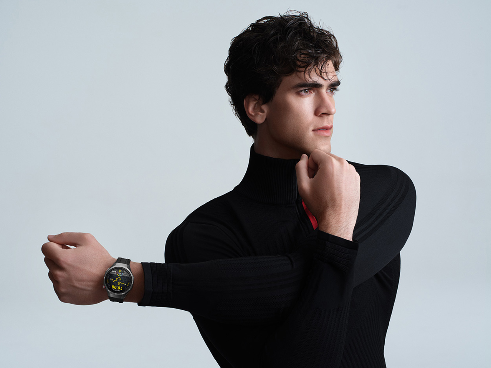 Un uomo in nero si allunga il braccio, indossa uno smartwatch.