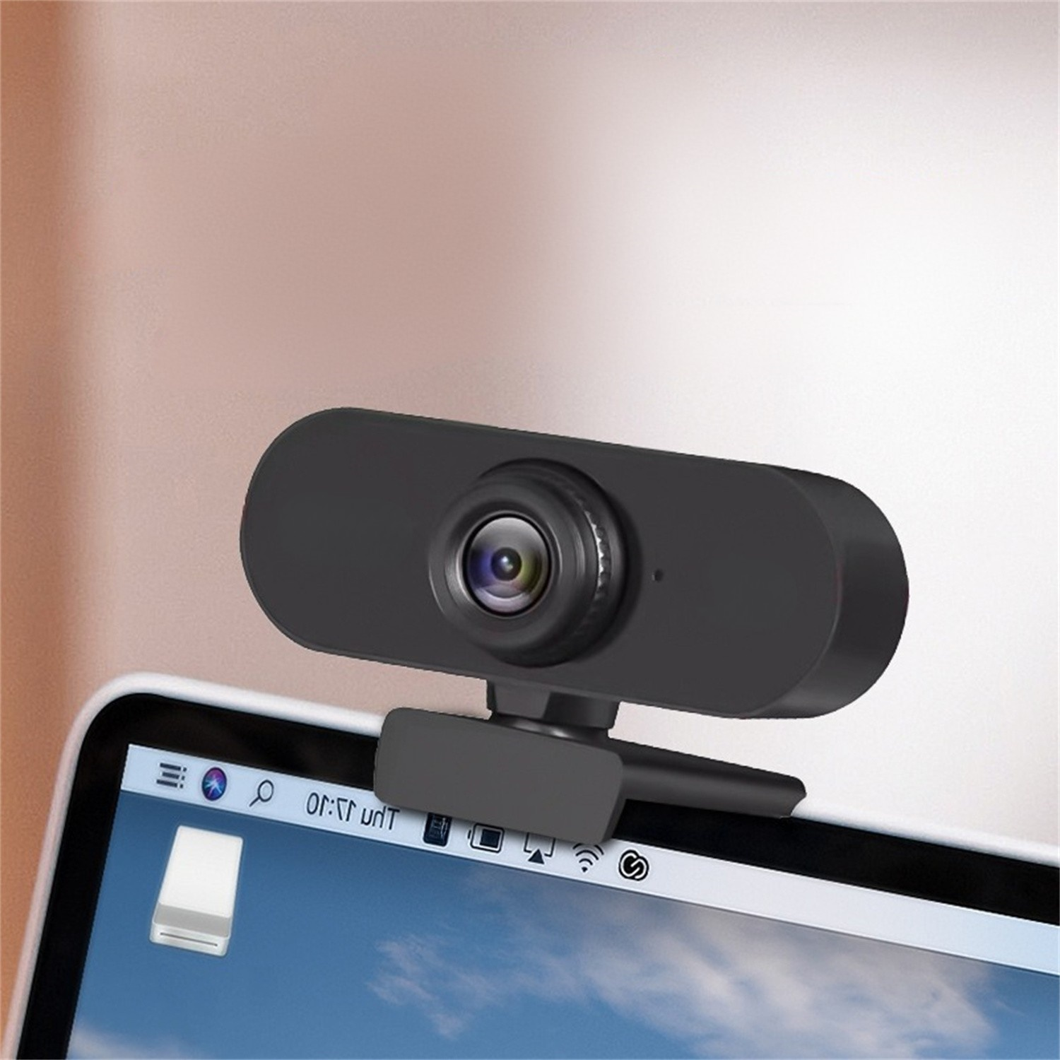 Eine schwarze Webcam ist auf einem Laptop montiert. Der Laptop zeigt einen Bildschirm mit einem Desktop.