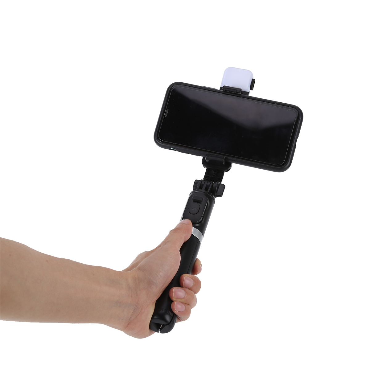 Eine Hand, die einen Selfie-Stick mit einem Telefon hält. Weißer Hintergrund.