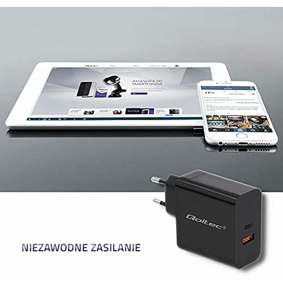 Tablet und Smartphone mit schwarzem Ladegerät auf reflektierender Oberfläche. Tablet zeigt Website, Telefon App.