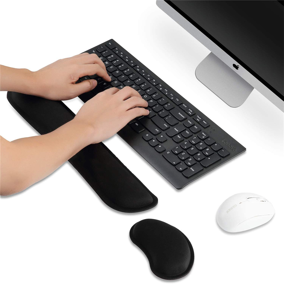 Hände tippen auf schwarzer Tastatur mit Handgelenkauflagen, Maus und Computerbildschirm.