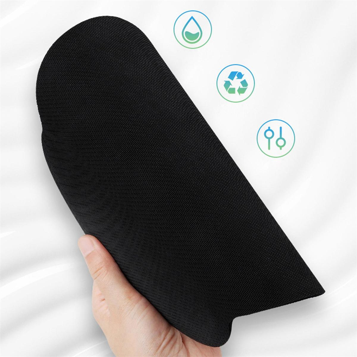 Eine Hand hält eine schwarze, strukturierte Matte mit umweltfreundlichen Symbolen darüber. Die Matte ist gefaltet.